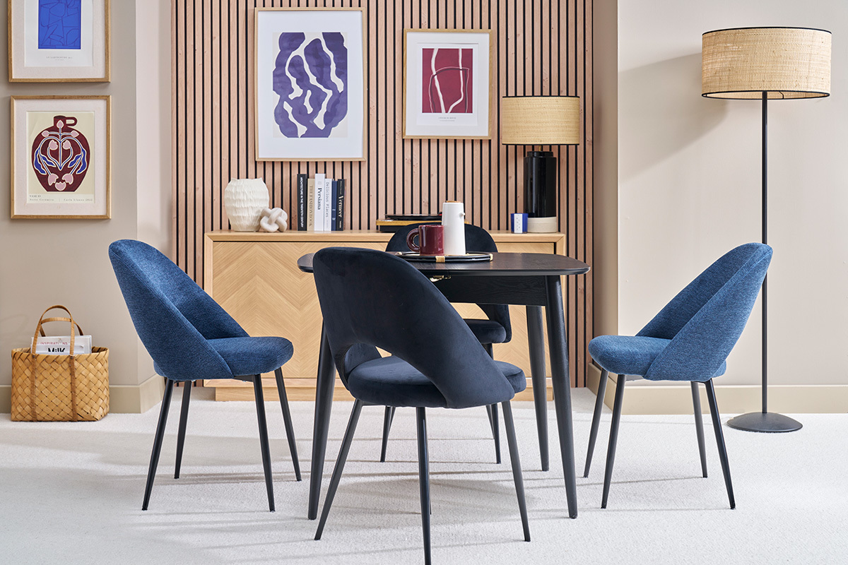 Tavolo da pranzo estensibile nero con sedie blu in un interno moderno.