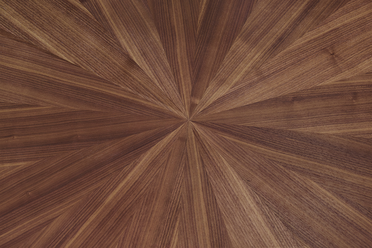 Primo piano sul piano ovale in impiallacciatura di noce con motivo sole del tavolo DIELLI.