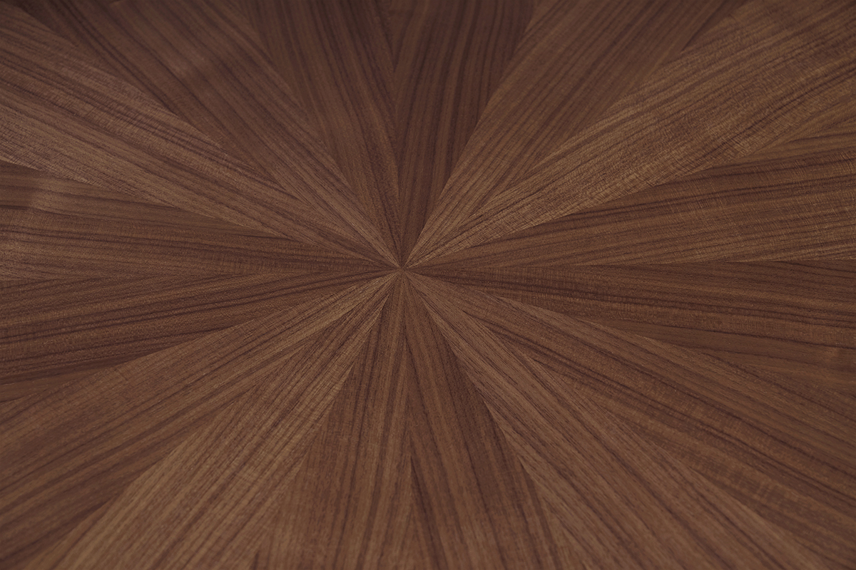 Dettaglio del piano in impiallacciatura di noce del tavolo rotondo DIELLI.