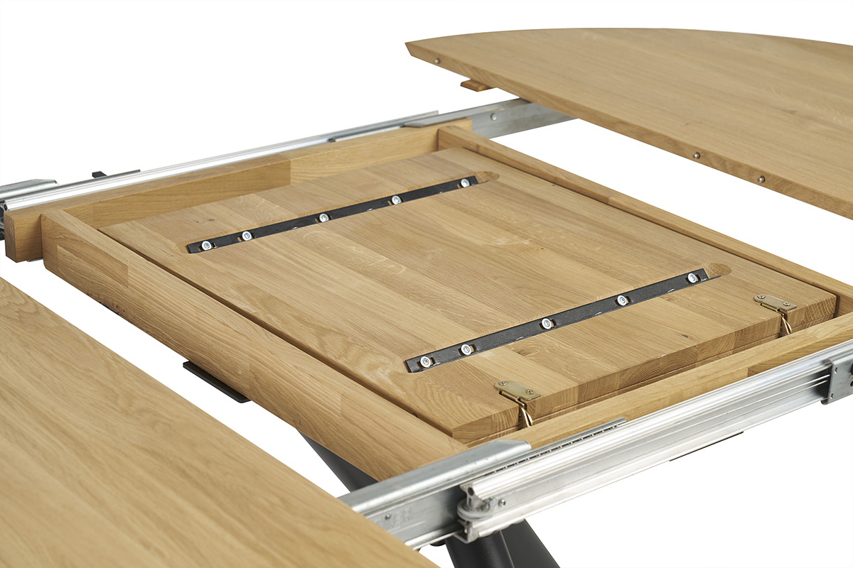 Meccanismo di estensione del tavolo da pranzo rotondo in quercia massello e metallo nero.