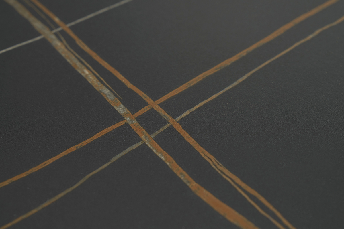 Dettaglio del vassoio in ceramica nera con motivi lineari arancioni del tavolo MALOU.