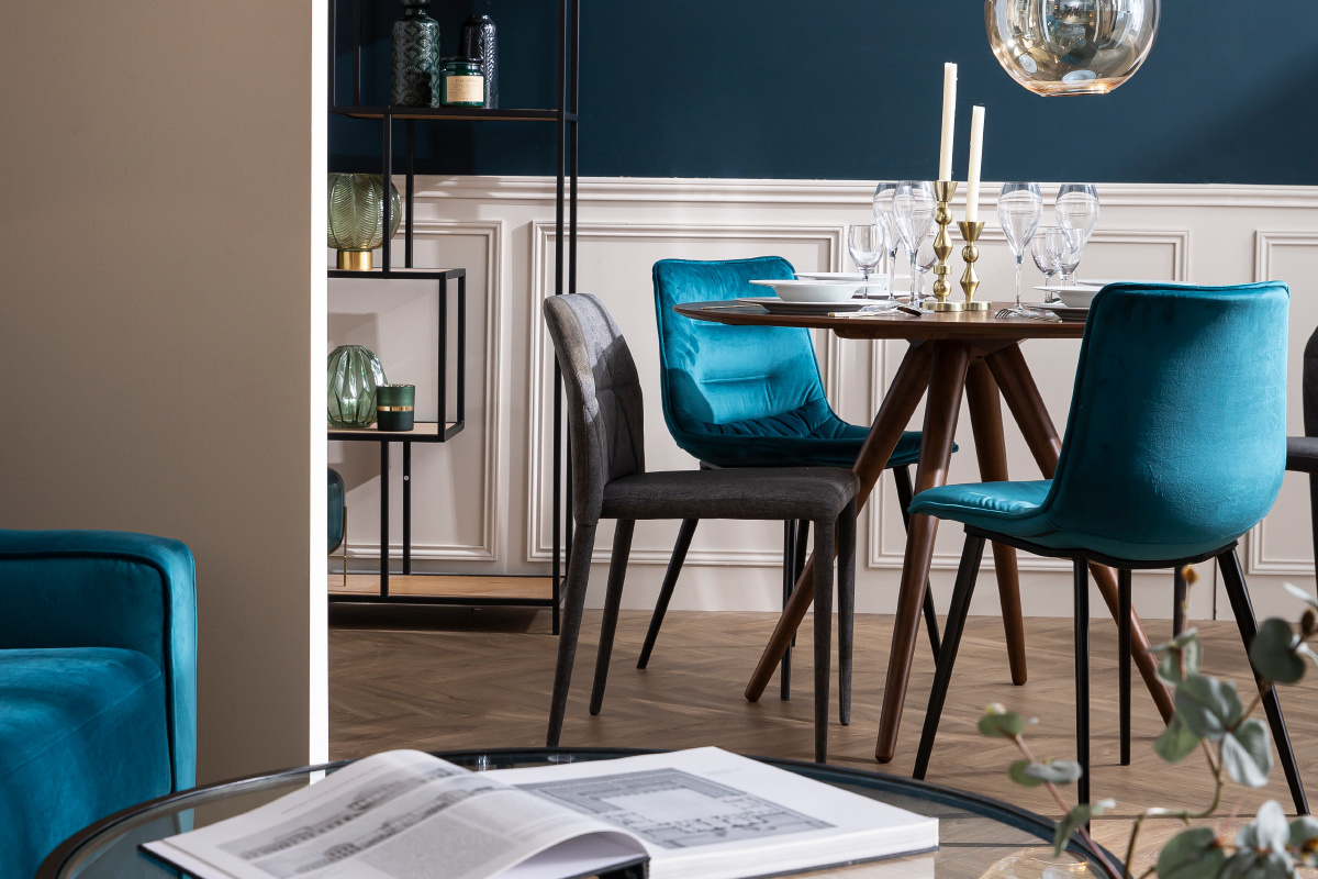 Tavolo da pranzo rotondo in legno scuro D106 cm WALFORD con sedie di design, vista in 3/4.
