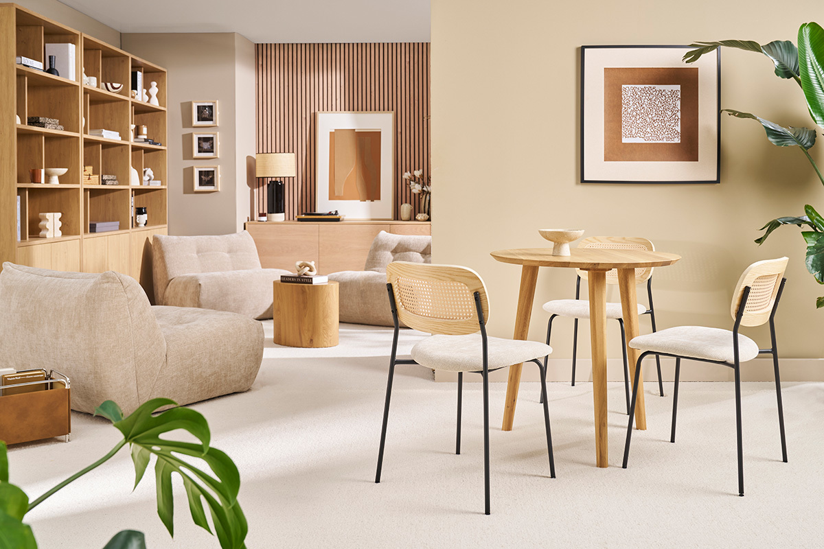 Tavolo rotondo in rovere chiaro con quattro sedie, vista interna di un soggiorno moderno.