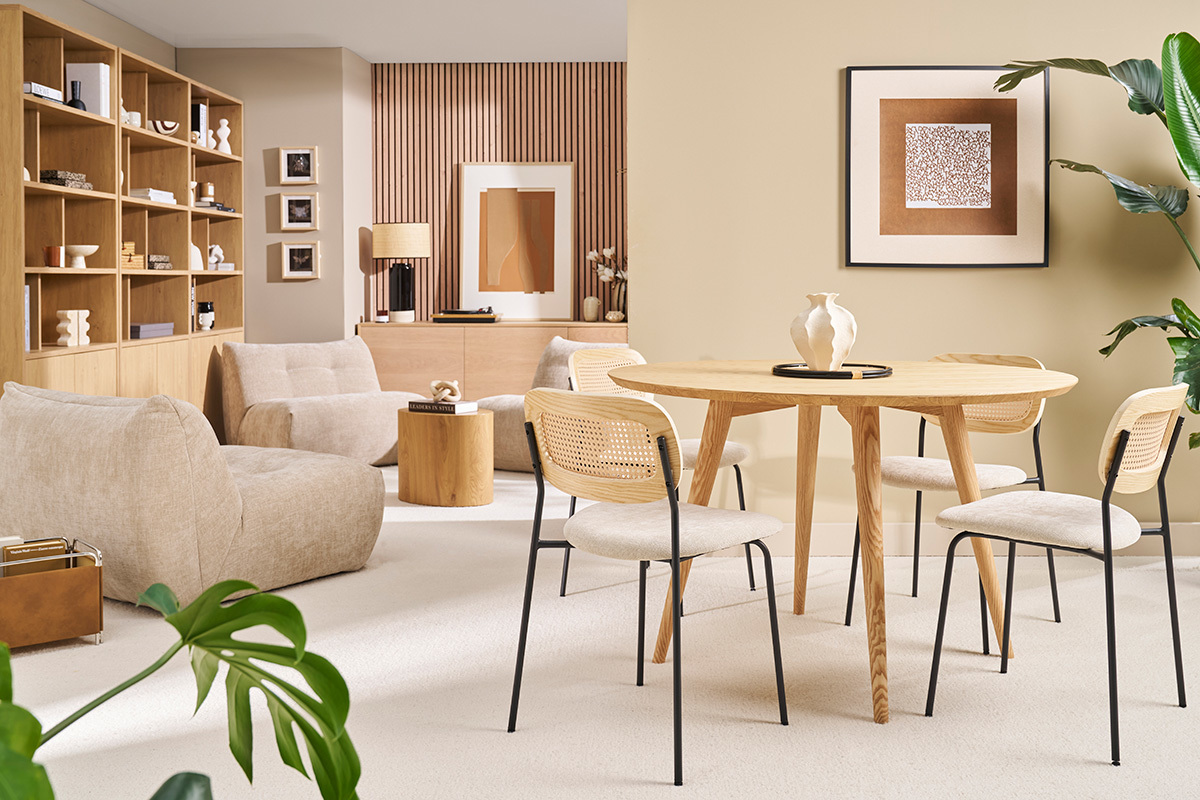 Tavolo rotondo in legno con quattro sedie in un soggiorno luminoso.