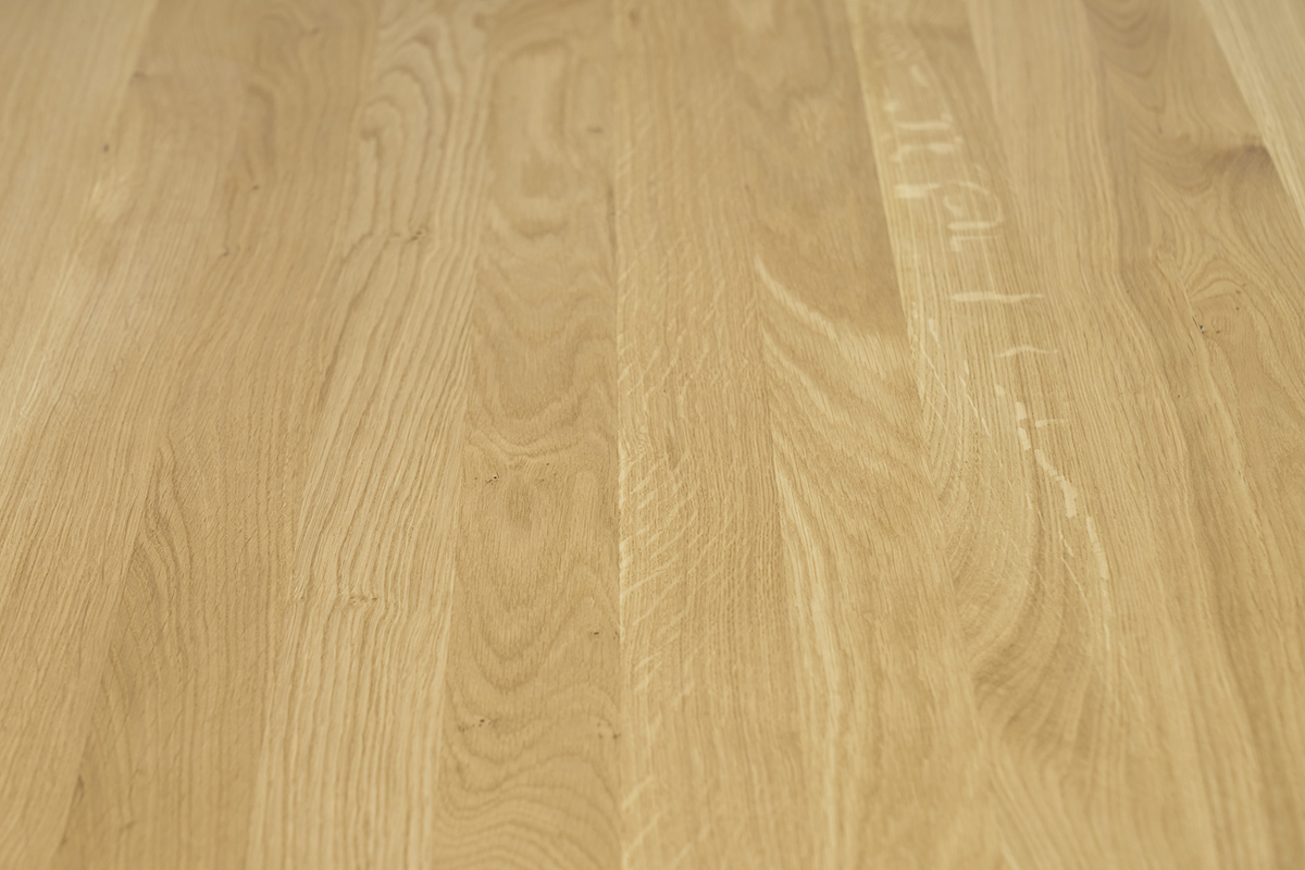 Tavolo da pranzo rotondo in quercia massiccia chiara, vista ravvicinata del piano.